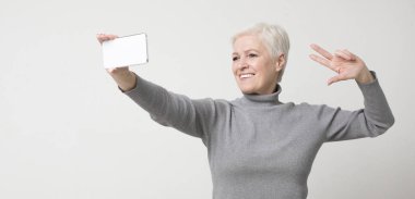 Modern son sınıf hanımı akıllı telefondan selfie çekiyor.