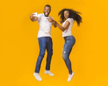 Güzel siyah adam ve kız atlarken selfie çekiyorlar.