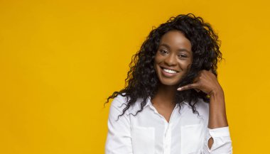 Pozitif Afro-Amerikalı kız, telefon çağrısı işareti yapıyor.