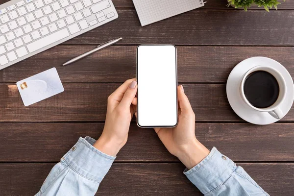 Жінка тримає смартфон з порожнім білим екраном в офісі — стокове фото