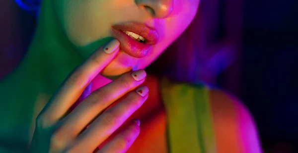 Model holding hand near lips in studio with neon lights — Stock Photo, Image