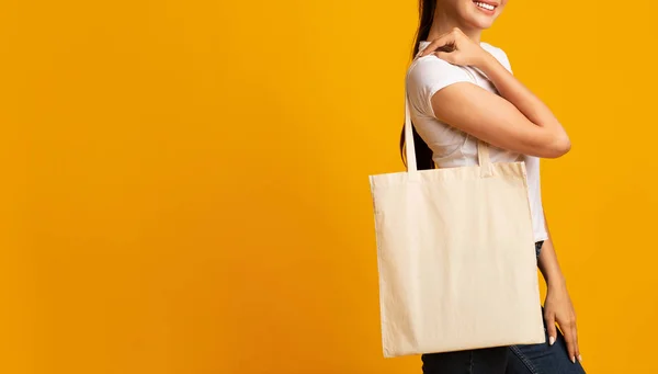Millennial menina carregando branco branco Eco saco sobre fundo amarelo — Fotografia de Stock