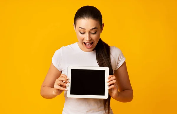Tablet Tutan Şaşırmış Kız Boş Ekran, Sarı Arkaplan — Stok fotoğraf