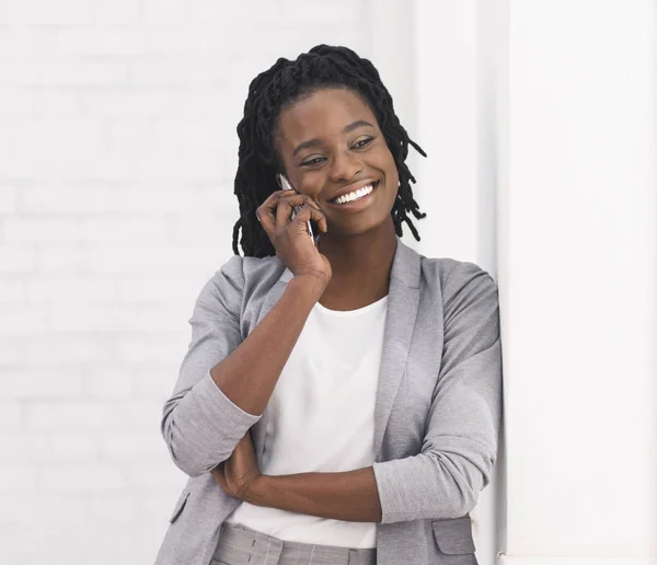 Afro Επιχειρηματίας Μιλώντας στο τηλέφωνο ενάντια στο λευκό τοίχο — Φωτογραφία Αρχείου