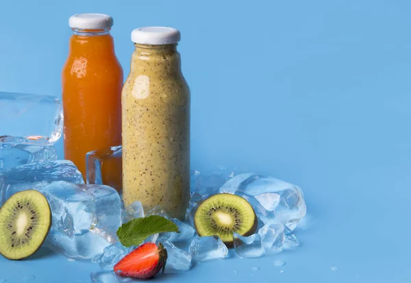 Summer drinks of fresh blended fruits in glass bottles