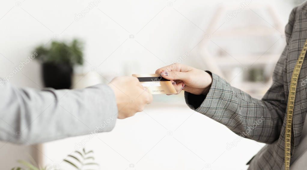 Woman buying clothes from designer, using credit card