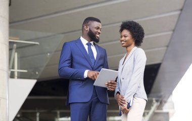 İnternette dijital tablette gezinen mutlu genç çalışanlar