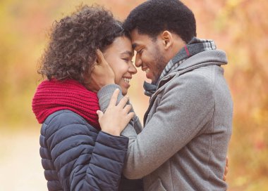 Şefkatli afro bir çift birbirlerine yapışıyorlar, alınlarına dokunuyorlar.