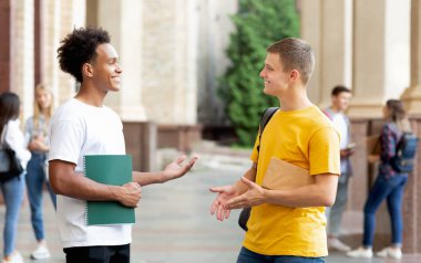 Neşeli öğrenciler dışarıda bir şeyler tartışıyor, ara veriyorlar.