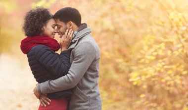 Huzurlu afro çift kucaklaşıyorlar ve alınlarına dokunuyorlar.