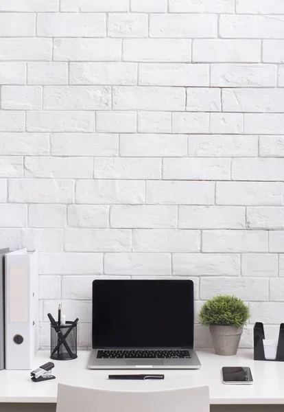 Modern white office desk with blank screen on laptop — Stock Photo, Image