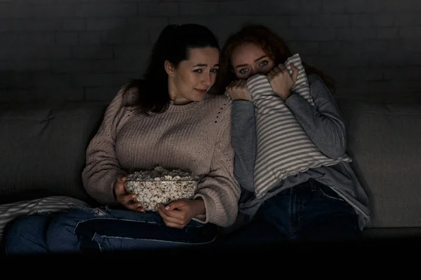 Tienermeisjes kijken naar horrorfilm met popcorn — Stockfoto