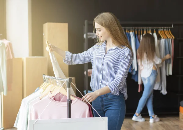 Blond jong vrouw op zoek naar mooie blouse — Stockfoto