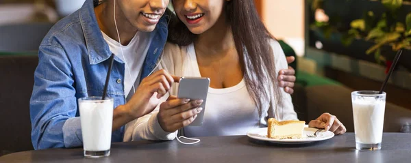 Couple of students watching videos on smartphone