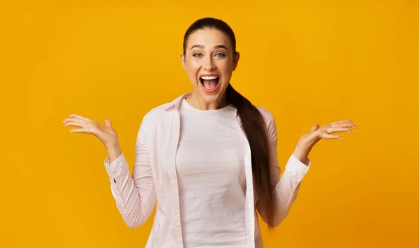 黄色のスタジオで成功を祝う幸せな若い女性の叫び背景 — ストック写真