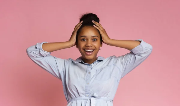 Excited girl holding hands on head, looking at camera — Stock Photo, Image