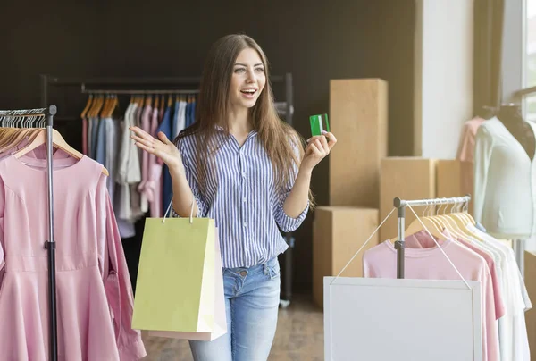 Chica súper emocionada sosteniendo bolsas de compras y tarjeta de crédito — Foto de Stock