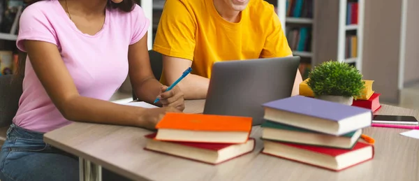 Casal de adolescentes trabalhando com projeto na biblioteca — Fotografia de Stock