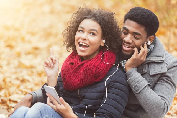 Pasangan bahagia menikmati jatuh di taman, mendengarkan musik — Stok Foto