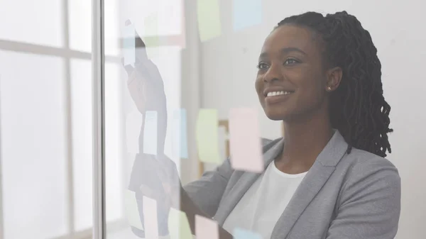 African American Business Lady Leyendo notas adhesivas en tablero de vidrio — Foto de Stock