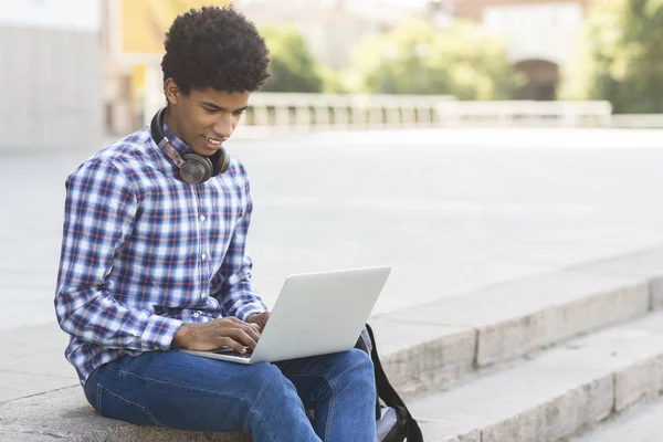 Πορτρέτο της αφρικανικής Αμερικανός έφηβος δακτυλογράφηση σε εξωτερικούς χώρους laptop — Φωτογραφία Αρχείου