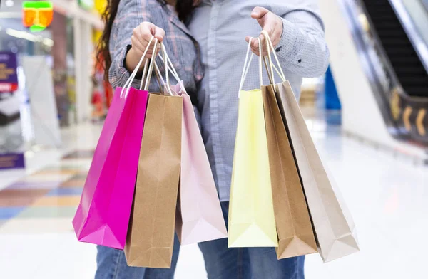 Shopping och rabatter. Par med papperspåsar i händerna — Stockfoto