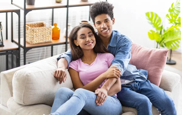 Felices amantes adolescentes descansando en casa, abrazándose en el sofá — Foto de Stock