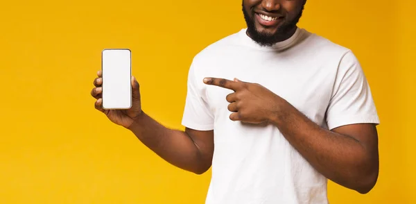 Hombre sosteniendo el teléfono inteligente con pantalla en blanco y apuntando a ella —  Fotos de Stock