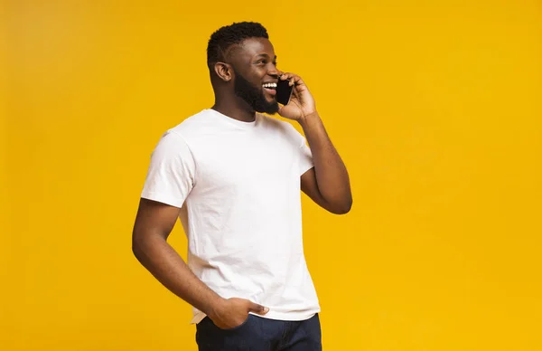 Portret van een lachende Afrikaanse man aan de telefoon — Stockfoto