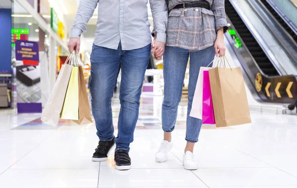 Pareja con coloridas bolsas de compras caminando en el centro comercial —  Fotos de Stock