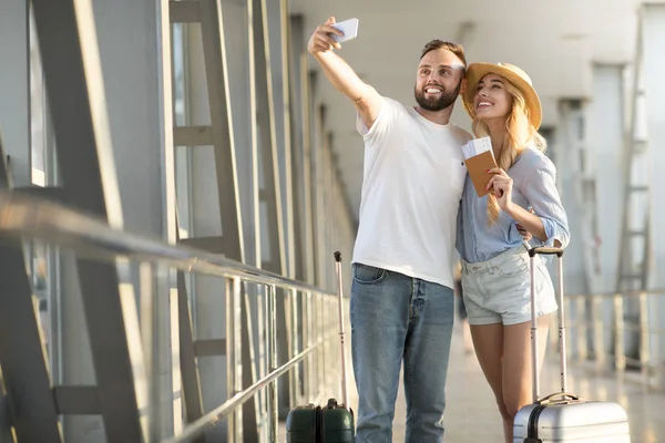 Nos encanta viajar. Pareja amorosa haciendo selfie en el aeropuerto — Foto de Stock