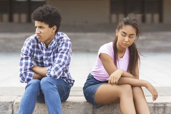 Urážené teen pár sedí venku, ignorují jeden druhého — Stock fotografie