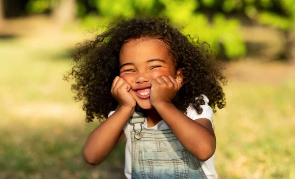 Engraçado menina afro tocando bochechas e se divertindo — Fotografia de Stock
