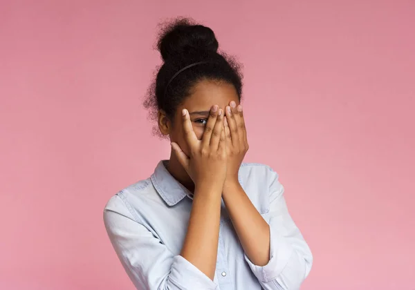 Nyfiken tonåring kikar genom fingrarna, täcker ansiktet med båda händerna — Stockfoto