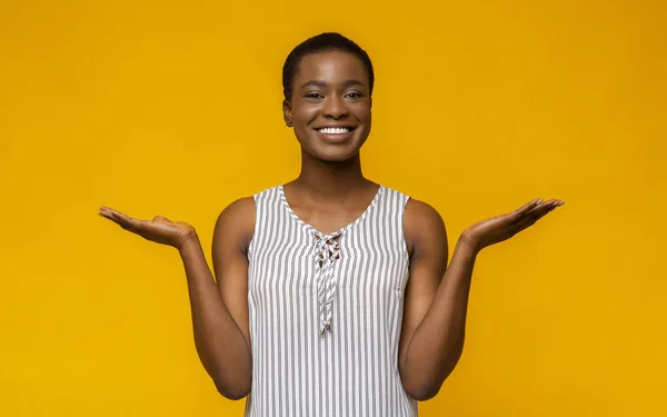 Zufrieden lächelnde schwarze Frau hebt in eureka-Geste die Hände — Stockfoto