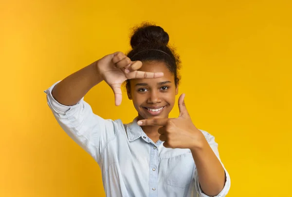 Menina adolescente africana feliz fazendo quadro de dedos — Fotografia de Stock