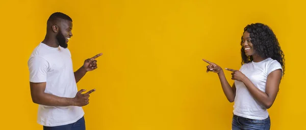 Happy black couple pointing at empty space in the middle — Stock Photo, Image