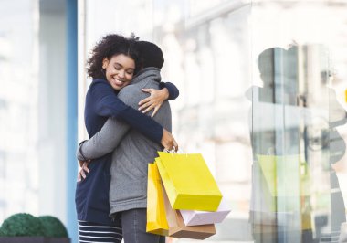 Sokakta alışveriş torbalarıyla sarılan genç aşıklar.