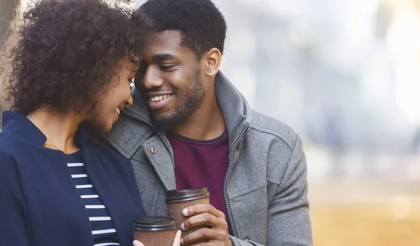 Afro homem e mulher aquecendo com café no parque — Fotografia de Stock