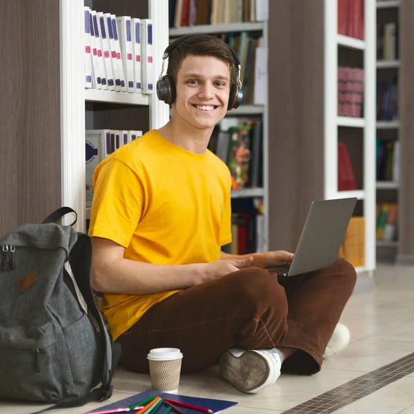 Retrato del estudiante alegre trabajando en un nuevo proyecto en la biblioteca — Foto de Stock