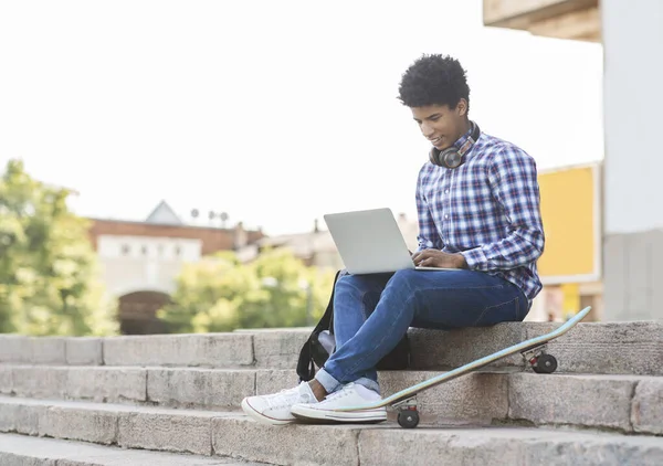 젊은 남학생 이 노트북을 사용하여 밖에서 공부하고 있다 — 스톡 사진