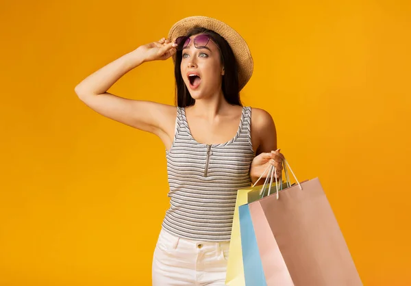 Emocionado Lady llevando coloridas bolsas de compras sobre fondo amarillo — Foto de Stock