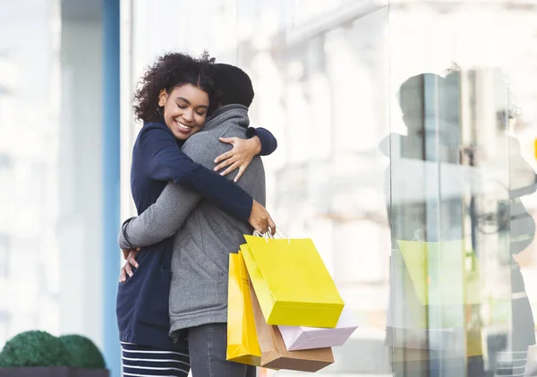 Młodzi kochankowie przytulają się do toreb na zakupy na ulicy — Zdjęcie stockowe
