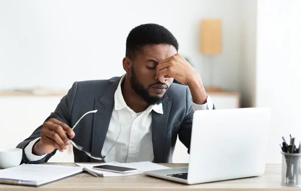 Overwerkt Afrikaans-Amerikaanse werknemer na harde dag in het kantoor — Stockfoto