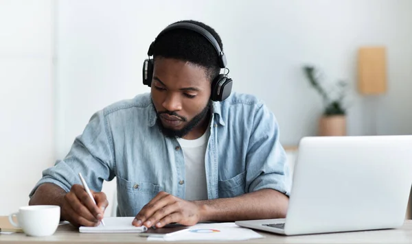 Σοβαρή Αφροαμερικανός φοιτητής στα ακουστικά που σπουδάζουν ξένη γλώσσα σε απευθείας σύνδεση — Φωτογραφία Αρχείου