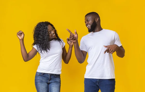 Atraente casal negro dançando no fundo do estúdio amarelo — Fotografia de Stock