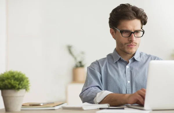 Concentrado Millennial Guy trabalhando no laptop no trabalho — Fotografia de Stock