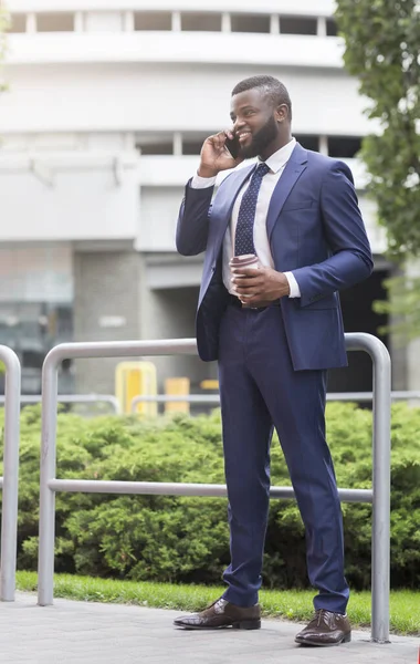 Afrika kökenli Amerikalı iş adamı dışarıda cep telefonuyla konuşuyor.