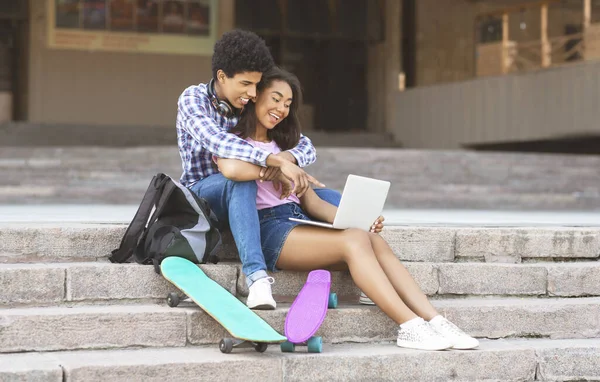 Jóvenes adolescentes alegres navegando video en el portátil al aire libre — Foto de Stock