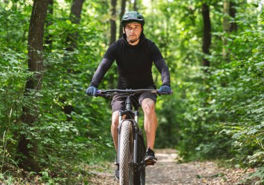 Dağ ormanında konsantreli bisikletçi.